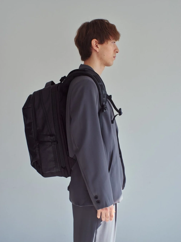スーツの男性がバックパックを背負っている