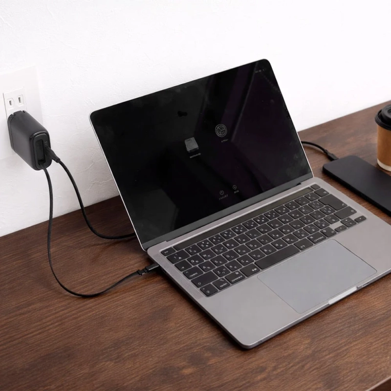 ノートPCと充電器がデスクにある画像