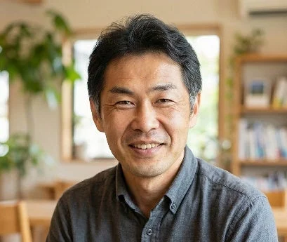 笑顔でカメラを見るITmedia PC USER田中宏昌編集長