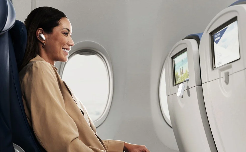 AirFly Pro 2で機内エンターテイメントを楽しむ女性