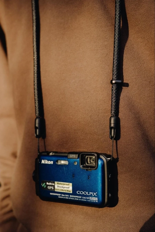 Nikon COOLPIXを首から下げた人物