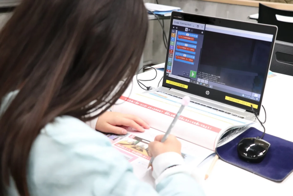 子どもがノートパソコンでマインクラフトのプログラミング学習に取り組む様子