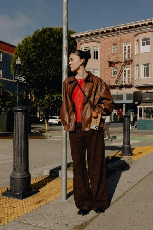 女性がスマホケースをストラップで持っている