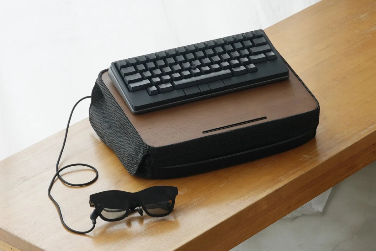 木製の台の上に置かれたミニマルなキーボードとスマートグラス