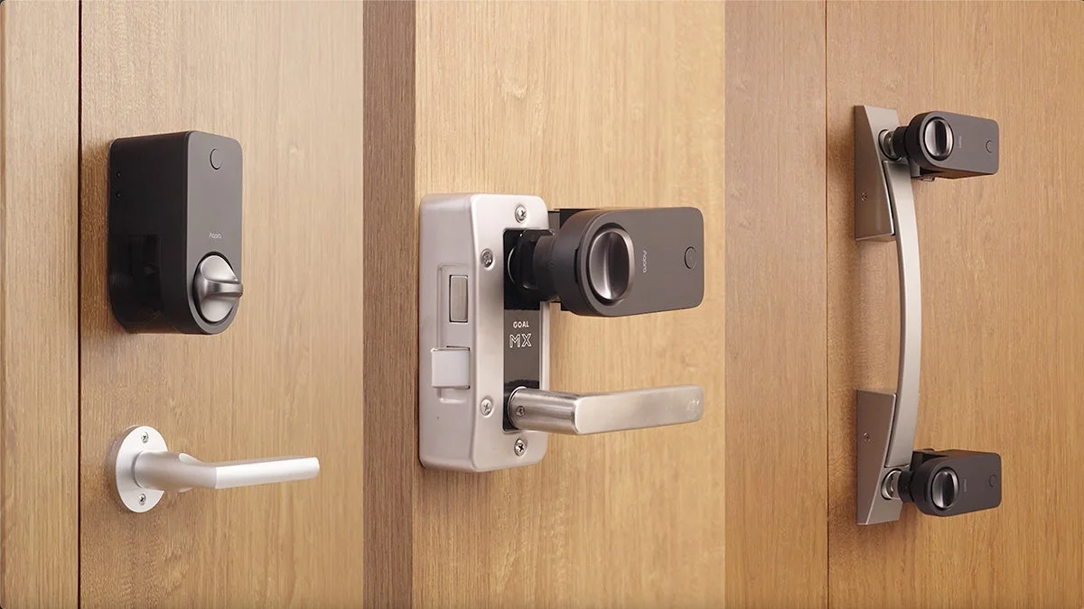 木製のドアに設置された3種類のスマートロックまたはドアハンドル用アタッチメントデバイスの比較画像。Aqara製のスマートホームセキュリティ製品と見られます。