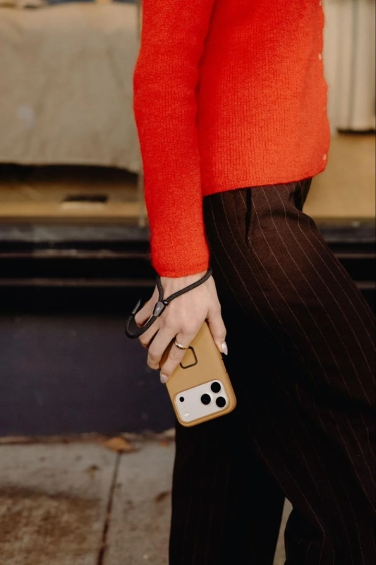 スマホをリストストラップで持っている手元