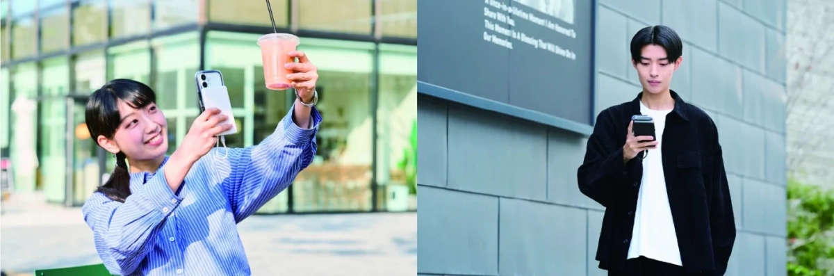 屋外でスマートフォンを使う2人の若者