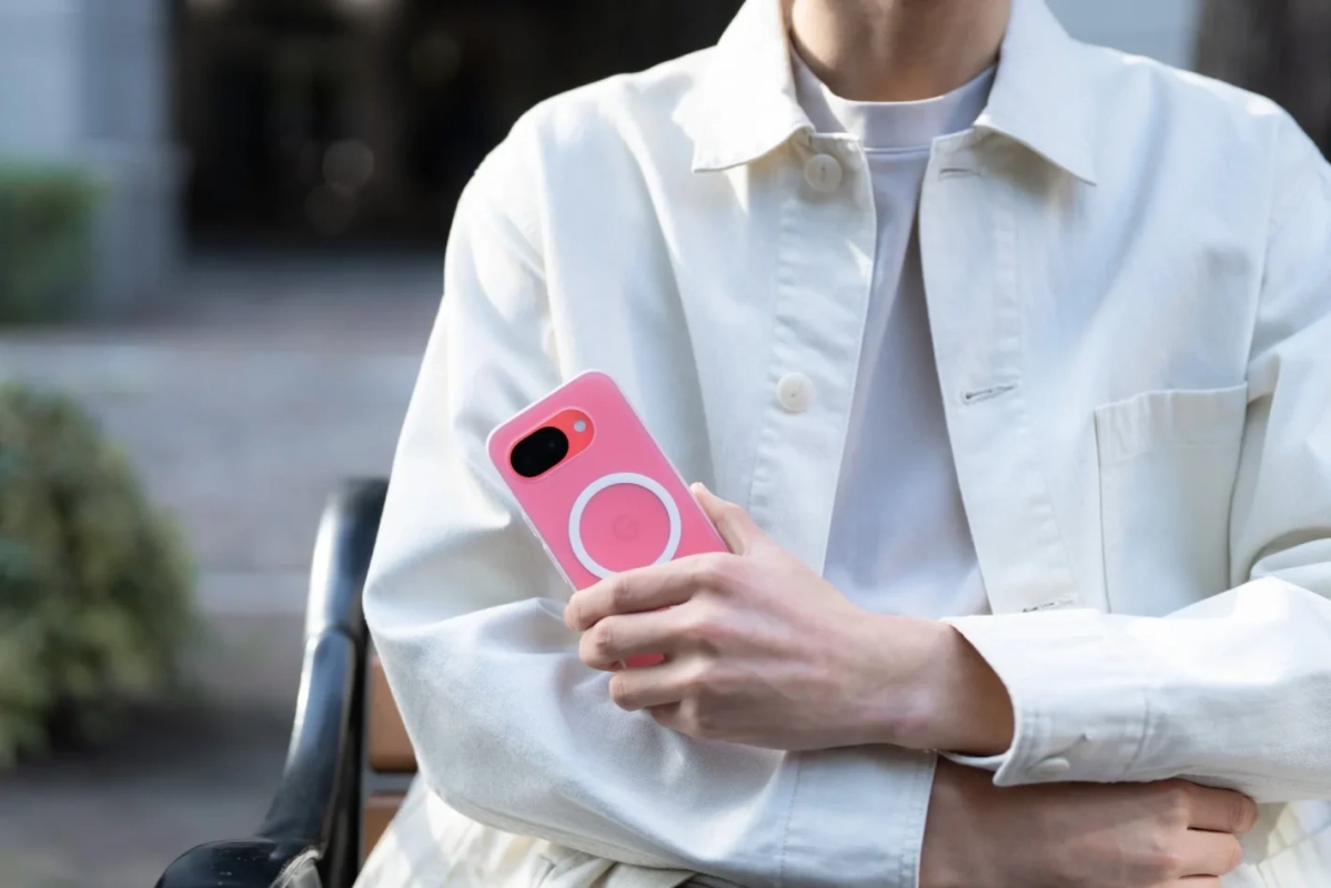 ピンク色のスマートフォンケースを持つ人物