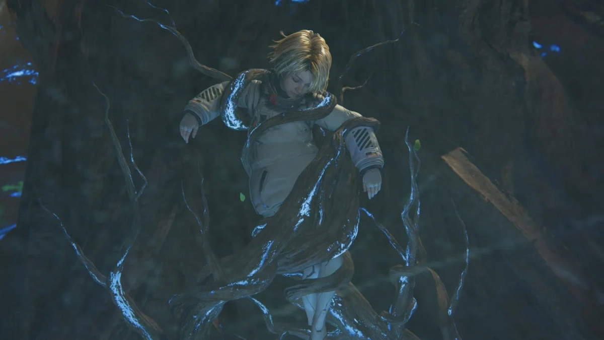 暗く神秘的な洞窟の中で、金髪の人物が光る青い根に絡まっています