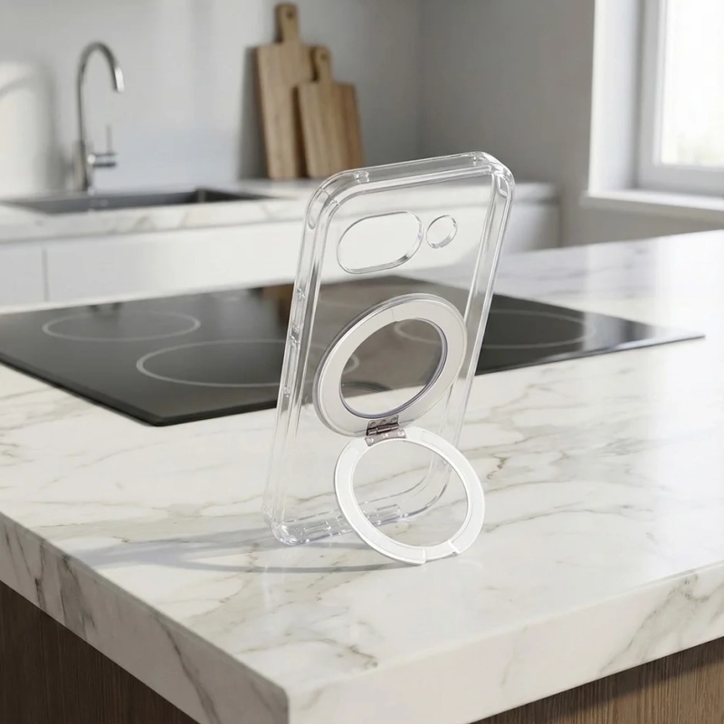 透明なスマートフォンケースが、リングスタンドを使って白い大理石のキッチンカウンターに立てかけられています