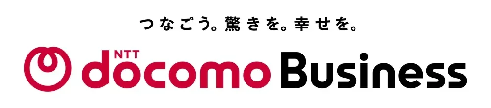 NTTドコモビジネスのロゴとスローガン「つながろう。驚きを。幸せを。」が白い背景に表示されています。ビジネス向けの通信サービスを示す画像です。
