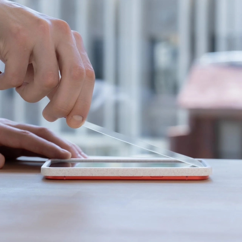 スマートフォンに画面保護フィルムを貼る様子