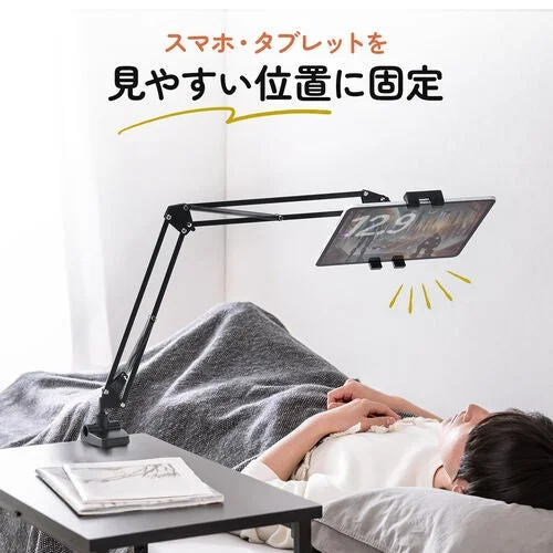 ベッドで横になりながらタブレットを見る様子