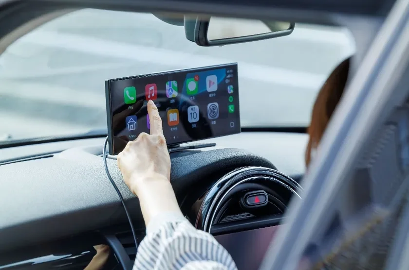 車内で、ドライバーがダッシュボードに設置されたディスプレイを操作している様子