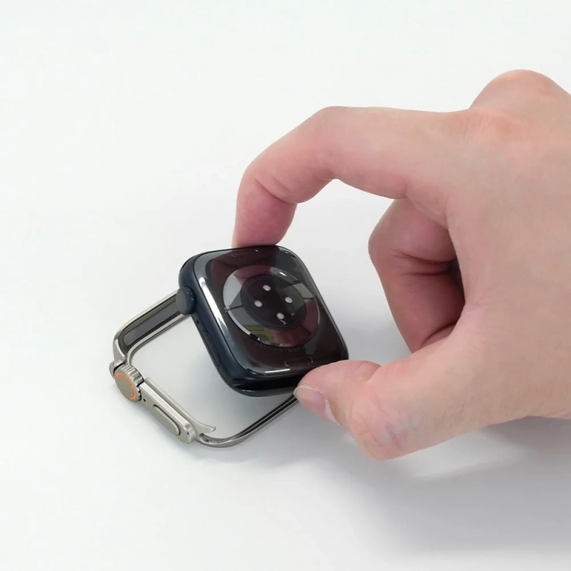 手がスマートウォッチに保護ケースを装着している様子