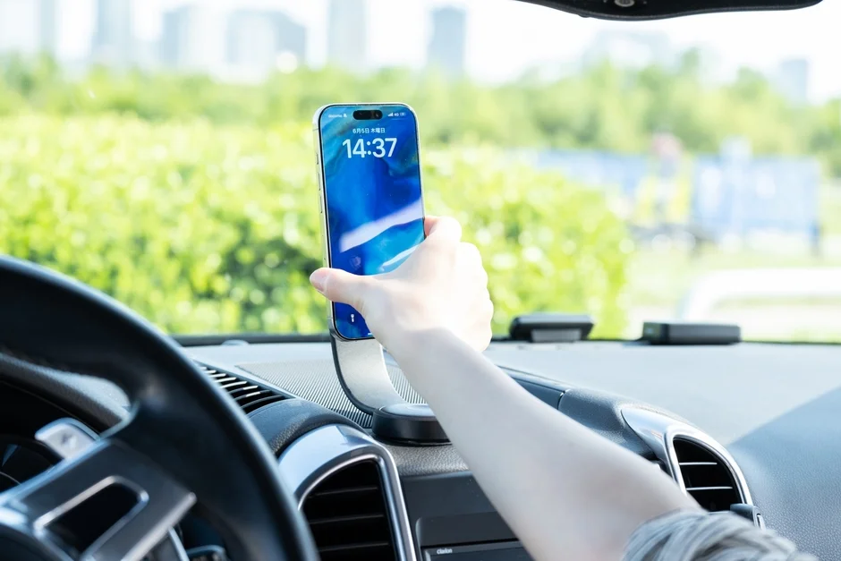 車内でスマートフォンを車載ホルダーに設置している様子