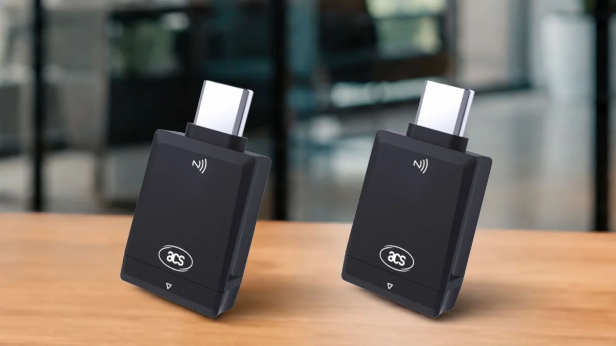 木製のテーブルに置かれた2つの黒いUSB-C非接触型リーダー（ドングル）。NFC/RFIDシンボルと「acs」ロゴが特徴で、電子認証や決済デバイスとして利用されるガジェットのようです。