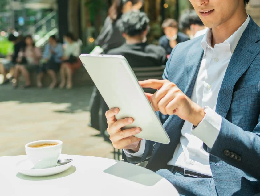 カフェでタブレットを操作するビジネスマン