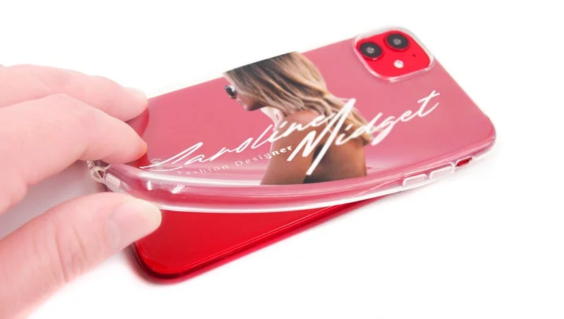 赤のiPhoneに女性のポートレートと「Caroline Midget Fashion Designer」の文字がプリントされたクリアケースを装着している様子