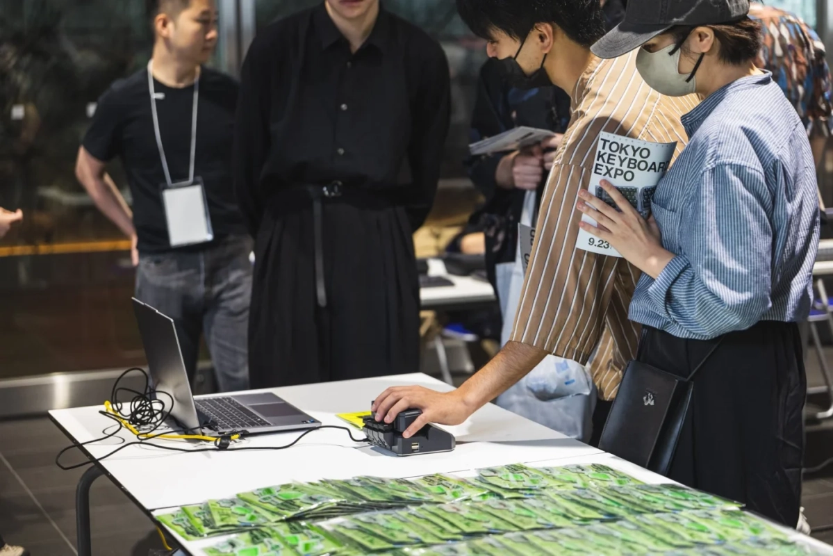 イベント会場で展示されたノートPCやキーボード関連商品を見ている人々