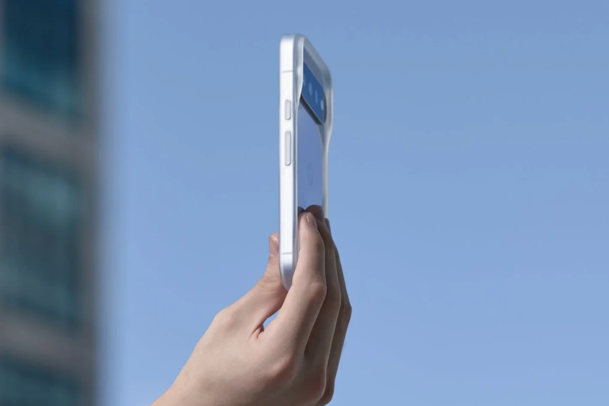 青空を背景に透明ケースのスマートフォンを持つ手