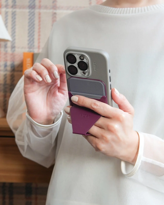女性がグレーのスマホとパープルのスタンド