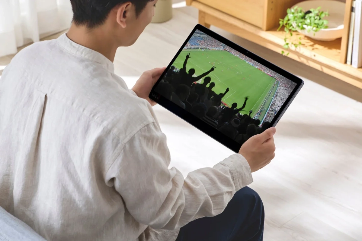 タブレットでサッカー観戦を楽しむ男性