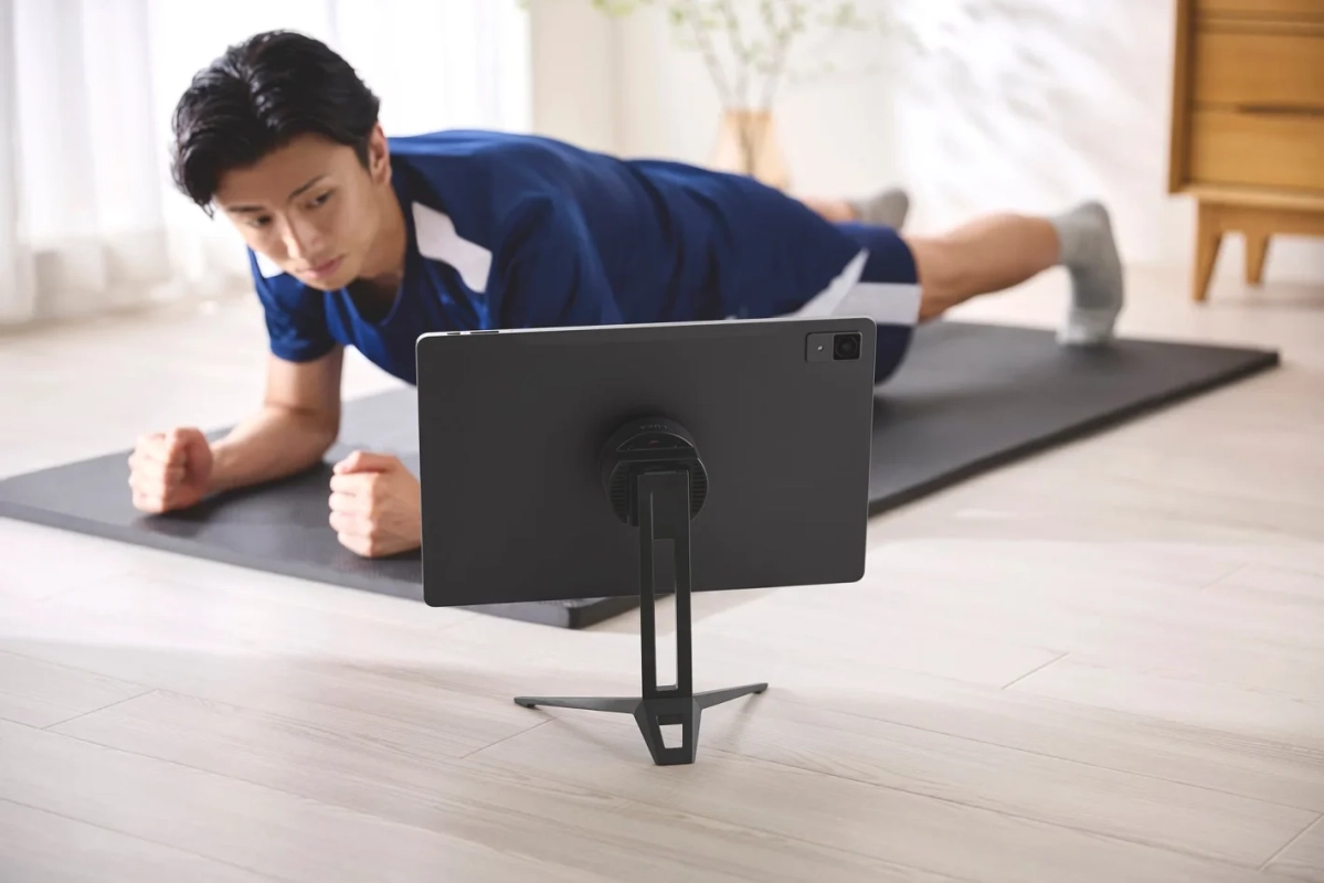 スタンドでトレーニング動画を見る男性