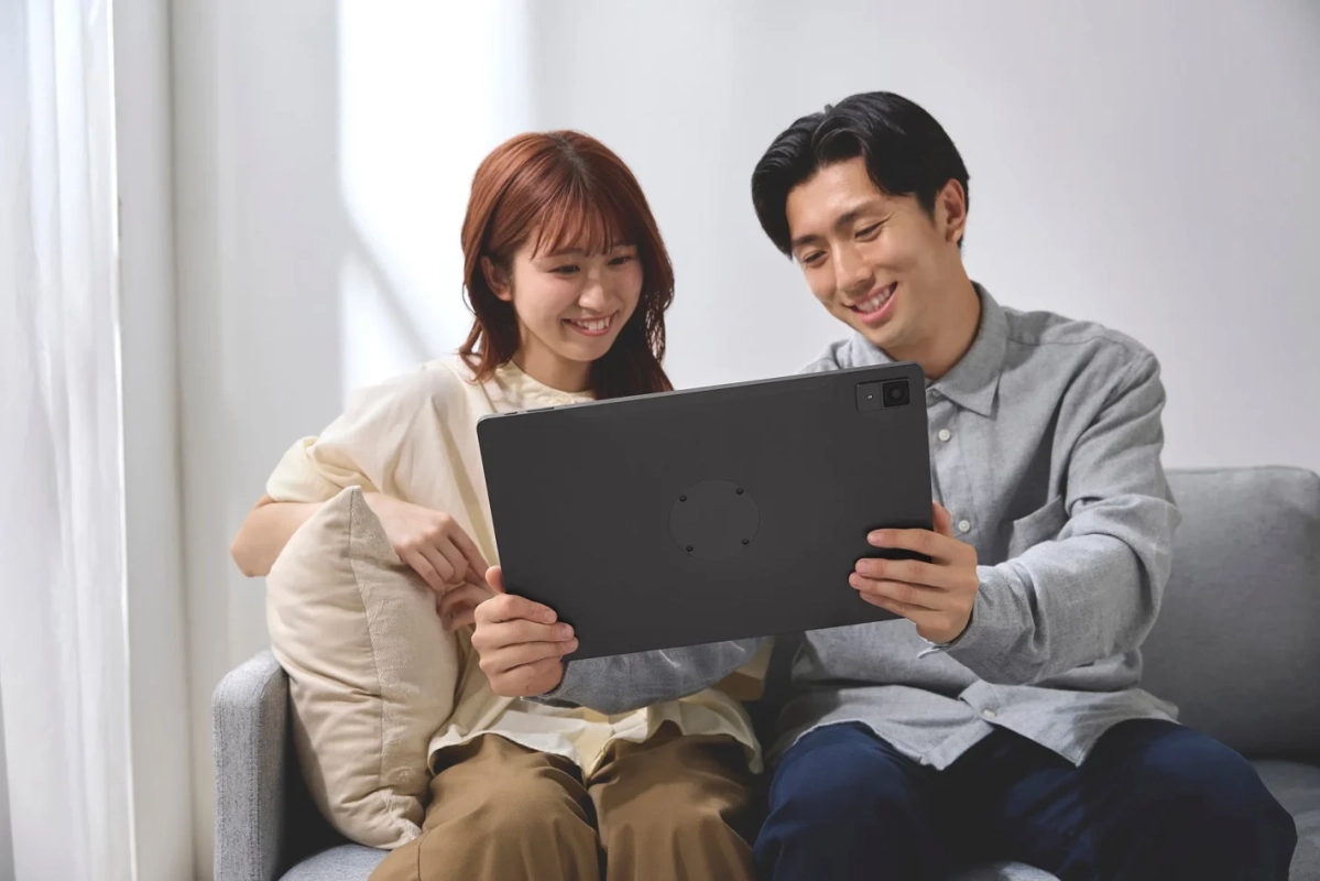 ソファでタブレットを共有するカップル